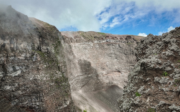 Crater of Mount Vesuvius with rocky walls and clear sky above.