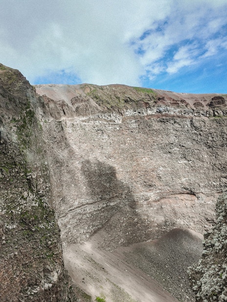 Crater of Mount Vesuvius with rocky walls and clear sky above.
