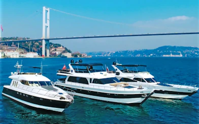 Luxury yachts on the Bosphorus with the Bosphorus Bridge in the background.