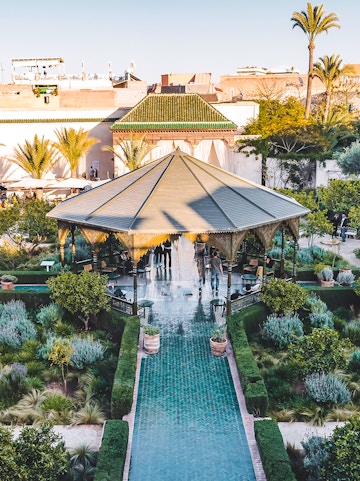 Jardin Secret pavilion with green tiled path and lush gardens in Marrakech.