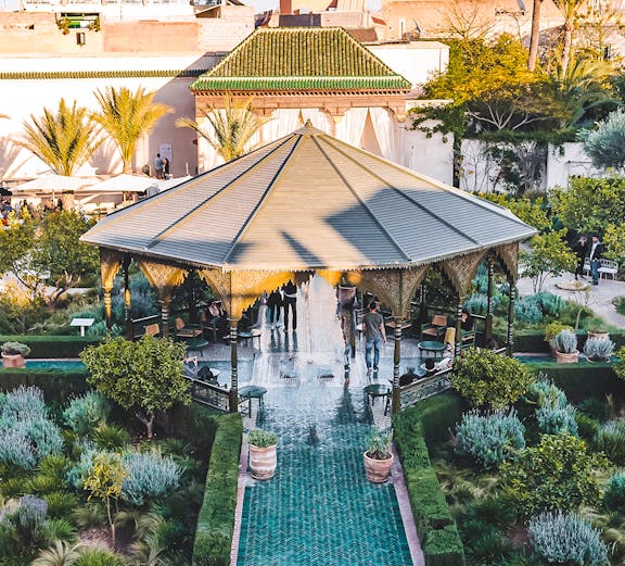 Jardin Secret pavilion with green tiled path and lush gardens in Marrakech.