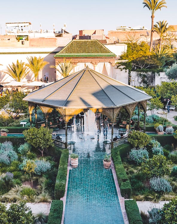 Jardin Secret pavilion with green tiled path and lush gardens in Marrakech.