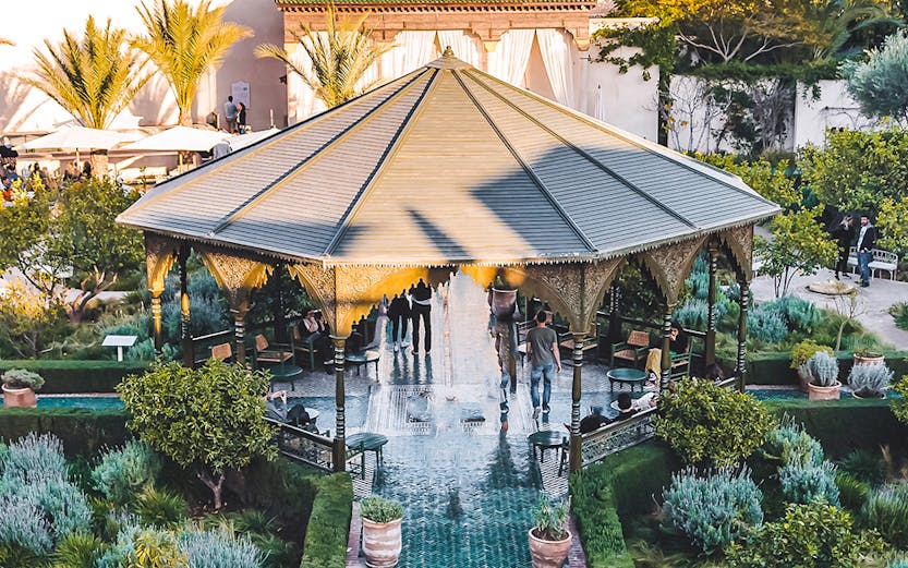 Jardin Secret pavilion with green tiled path and lush gardens in Marrakech.