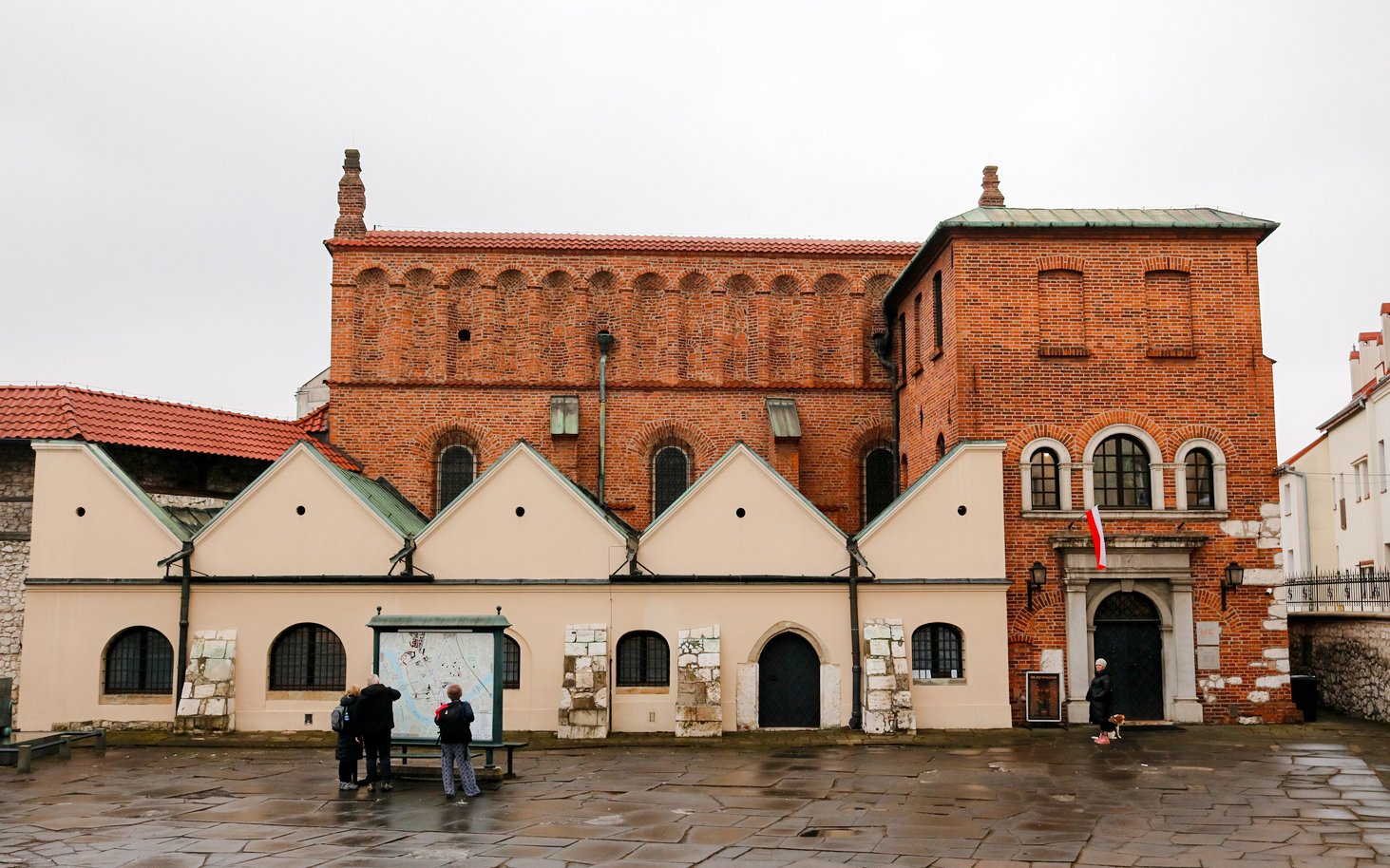 Exterior of Old Synagogue in Jewish Ghetto, Krakow, Poland with visitors reading a map.