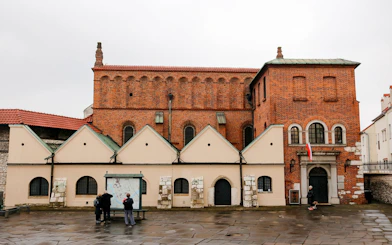 Exterior of Old Synagogue in Jewish Ghetto, Krakow, Poland with visitors reading a map.