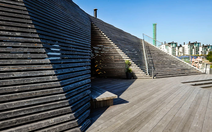 Löyly sauna's wooden terrace and unique architecture in Helsinki, Finland.