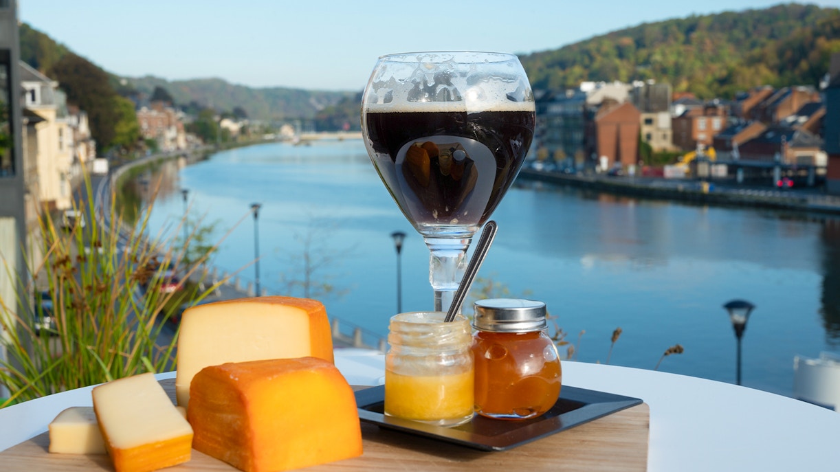 Trappist Westvleteren 12 Belgian ale bottle with glass in a rustic setting.