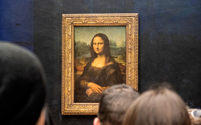 Visitors viewing the Mona Lisa at the Louvre Museum in Paris.