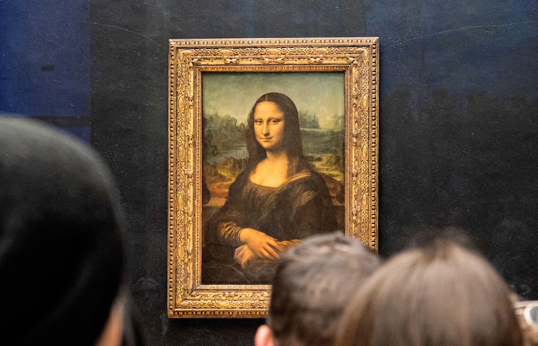 Visitors viewing the Mona Lisa at the Louvre Museum in Paris.