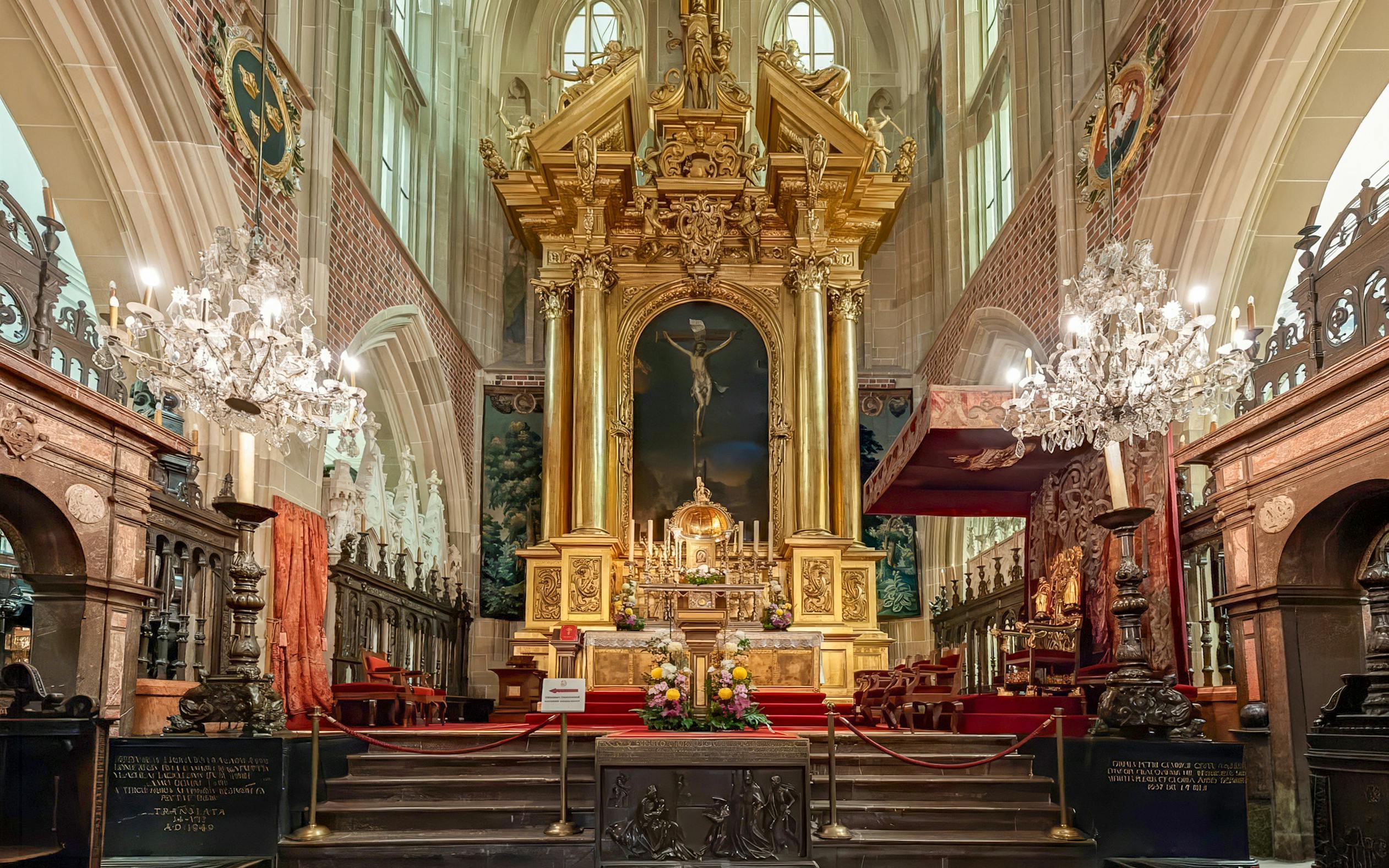 Altar inside Wawel Cathedral, Krakow, Poland with ornate gold detailing and chandeliers.