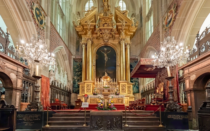 Altar inside Wawel Cathedral, Krakow, Poland with ornate gold detailing and chandeliers.