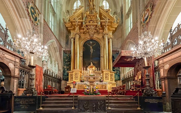 Altar inside Wawel Cathedral, Krakow, Poland with ornate gold detailing and chandeliers.