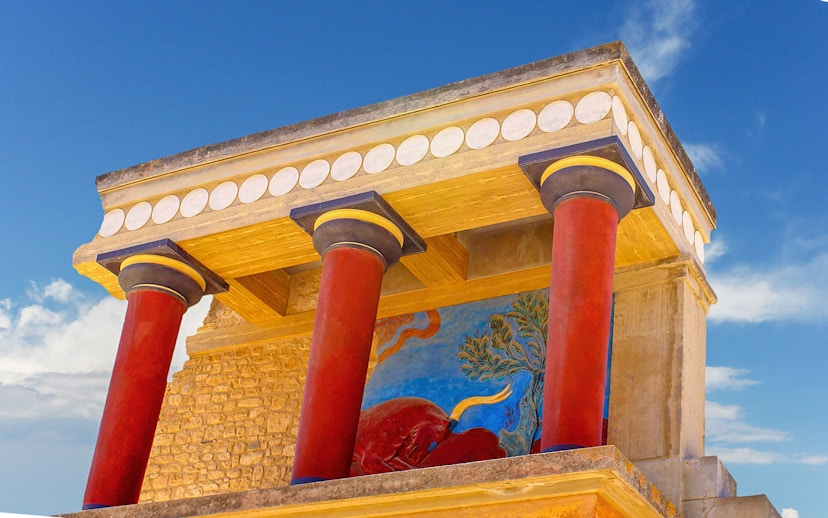 Knossos Palace fresco and red columns under blue sky, Crete, Greece.