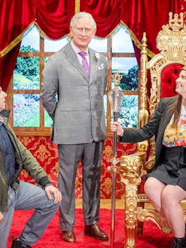 Wax figure of King Charles with visitors at Madame Tussauds Sydney.