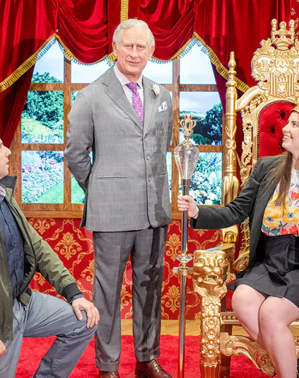 Wax figure of King Charles with visitors at Madame Tussauds Sydney.