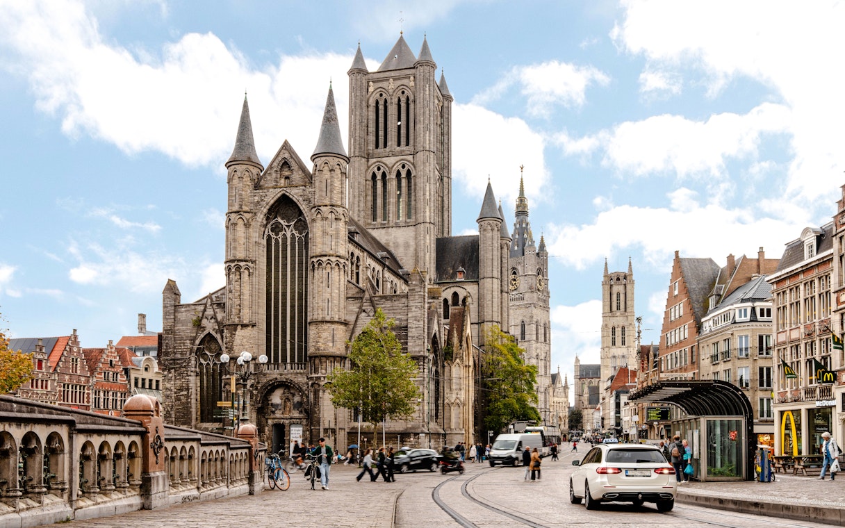 Street scene in Ghent, Belgium, with Saint Nicholas Church and bustling activity.