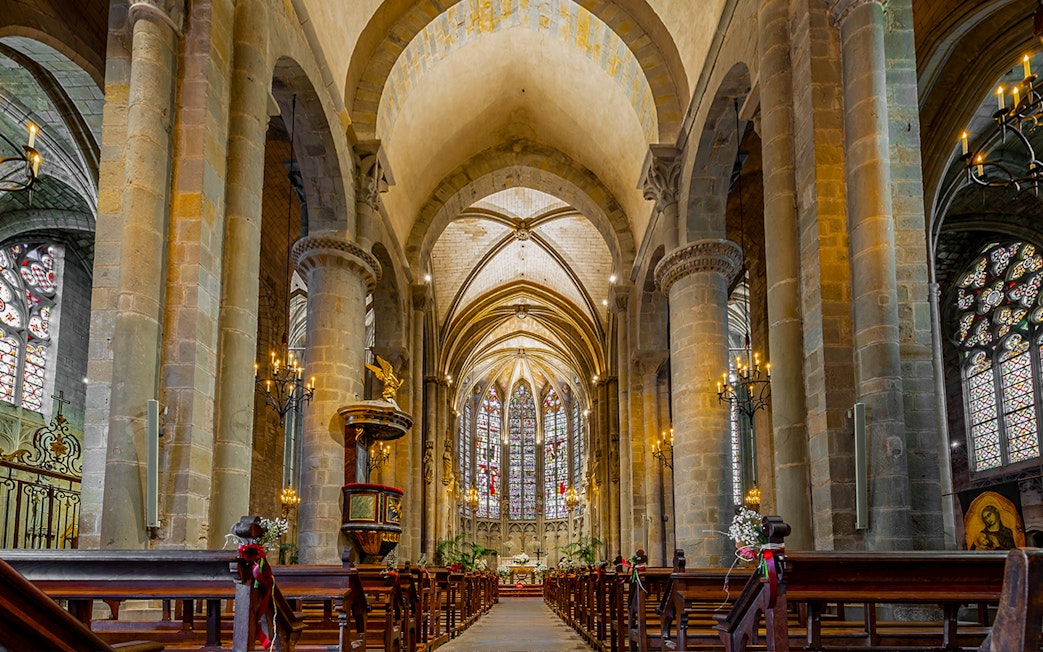 Interior of Basilique Saint-Nazaire Cathedral, Carcassonne Castle, featuring stained glass windows and vaulted ceilings.