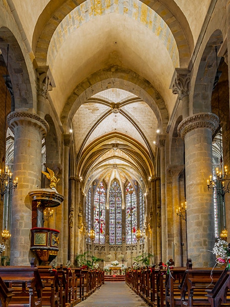 Interior of Basilique Saint-Nazaire Cathedral, Carcassonne Castle, featuring stained glass windows and vaulted ceilings.