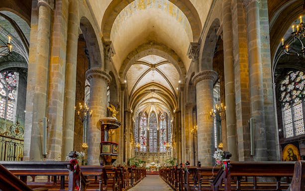 Interior of Basilique Saint-Nazaire Cathedral, Carcassonne Castle, featuring stained glass windows and vaulted ceilings.