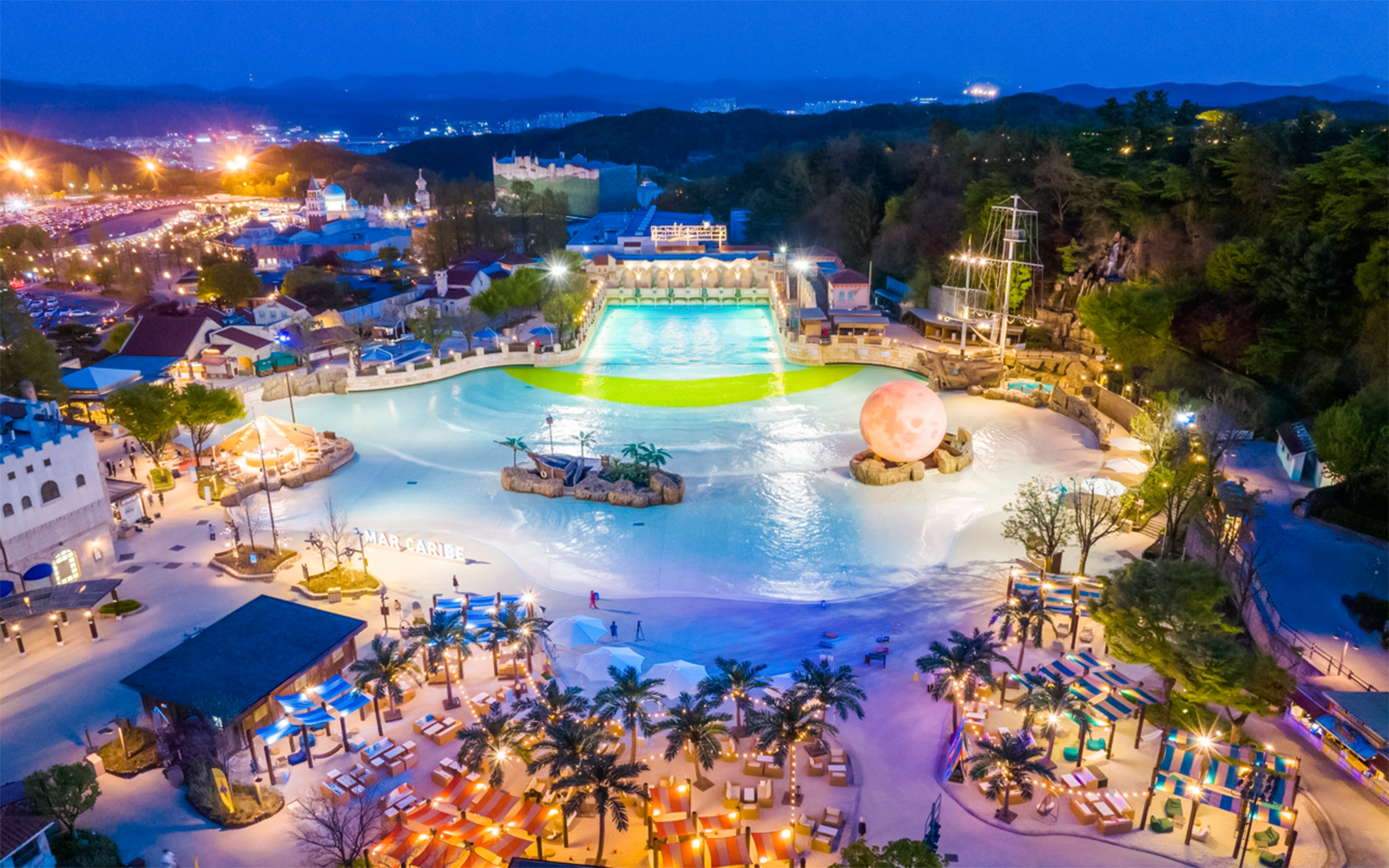 Night aerial view of Caribbean Bay Water Park with illuminated pools and attractions.