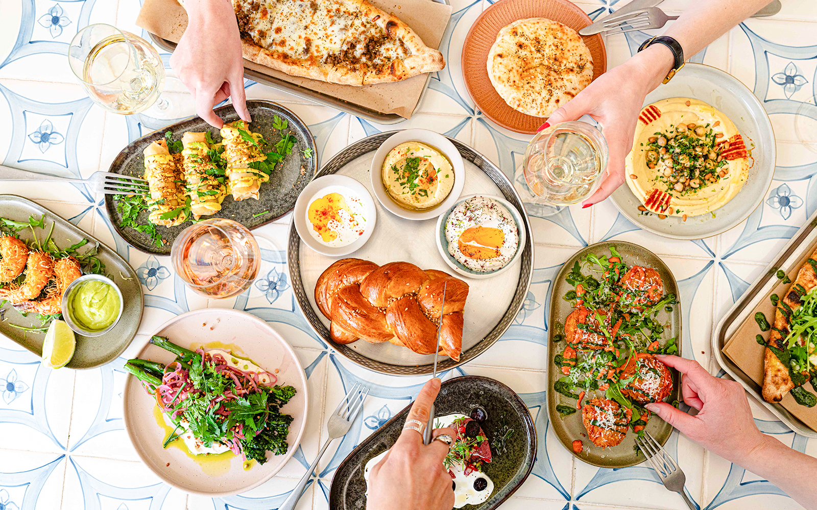 Assorted dishes and drinks on a table at Brasserie Auteuil, showcasing a diverse food palate.