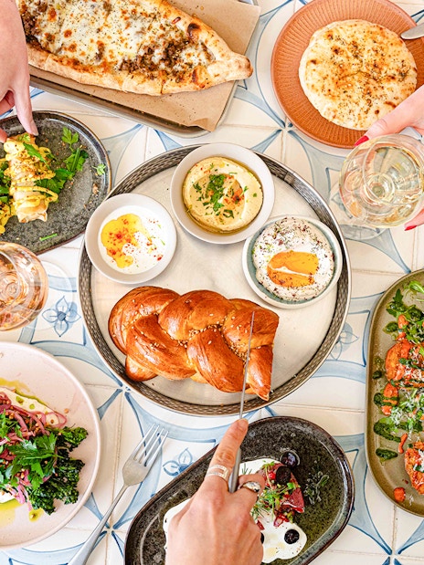 Assorted dishes and drinks on a table at Brasserie Auteuil, showcasing a diverse food palate.
