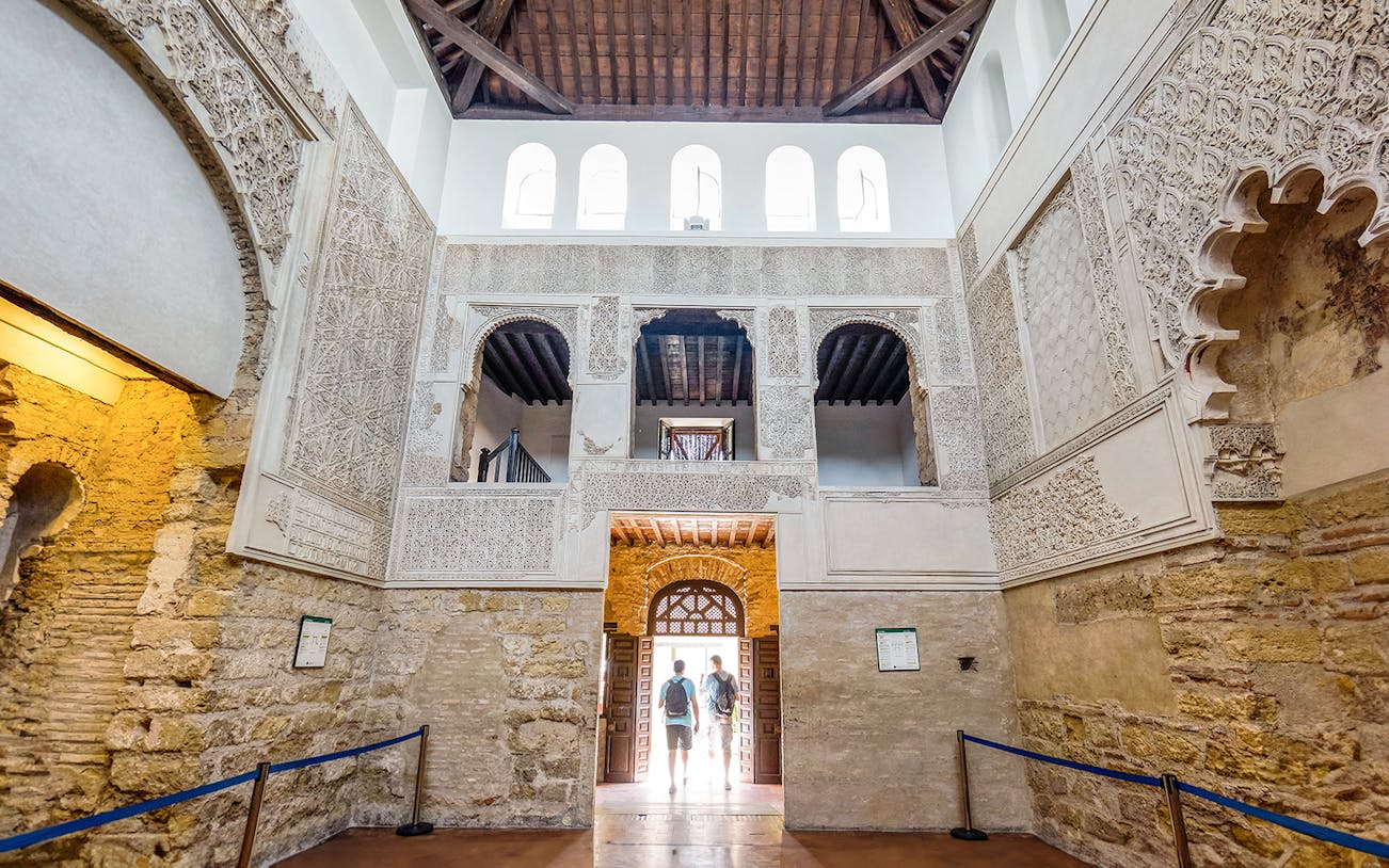 Interior of Córdoba Synagogue with intricate stone carvings and arched windows, part of Jewish Quarter tour.