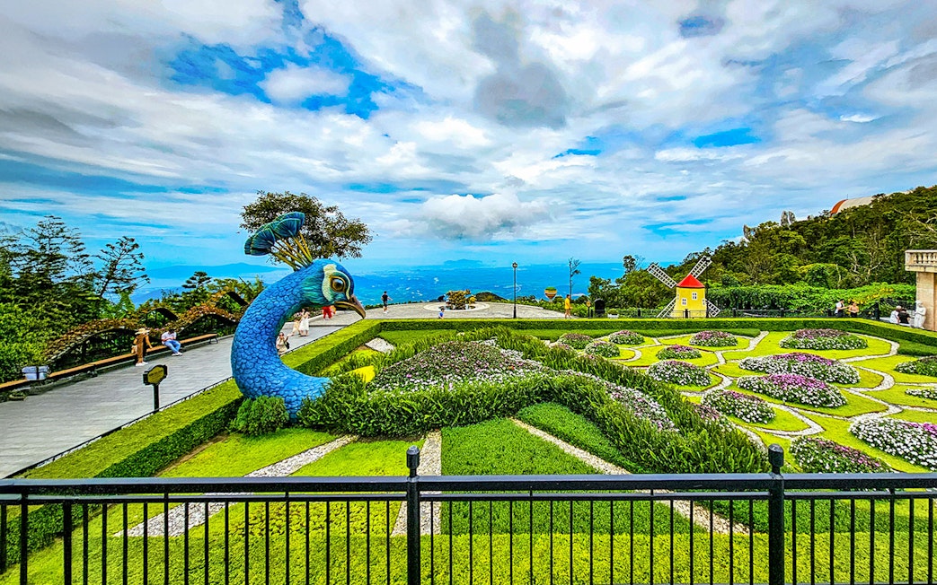 Garden with peacock sculpture and windmill at Sun World Ba Na Hills.