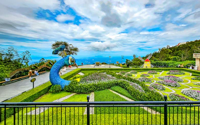 Garden with peacock sculpture and windmill at Sun World Ba Na Hills.