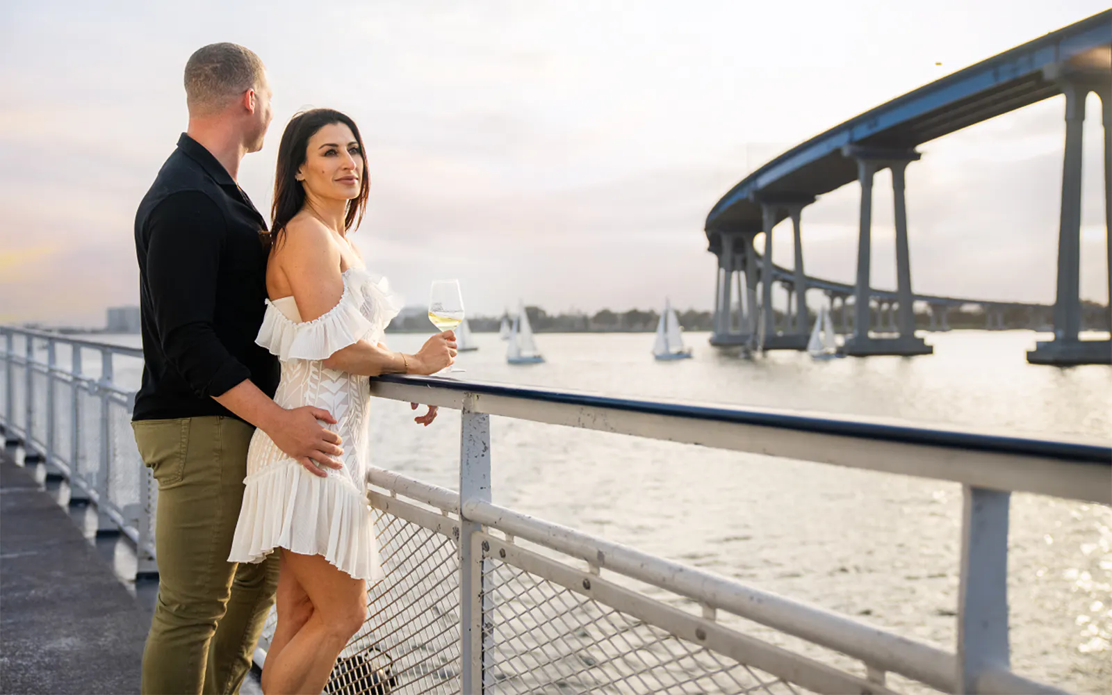 Guests enjoying city views on San Diego Premier Dinner Cruise near Coronado Bridge.