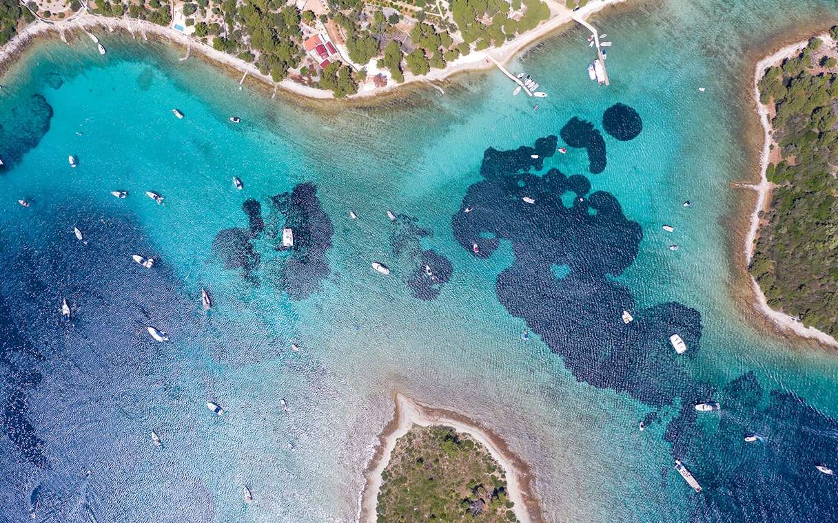 Aerial view of boats in the Blue Lagoon near Split, Croatia, surrounded by clear turquoise waters.