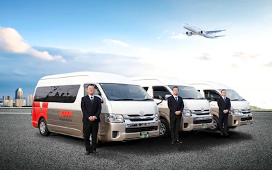 Kansai Airport shared shuttle vans with attendants and airplane in the sky.
