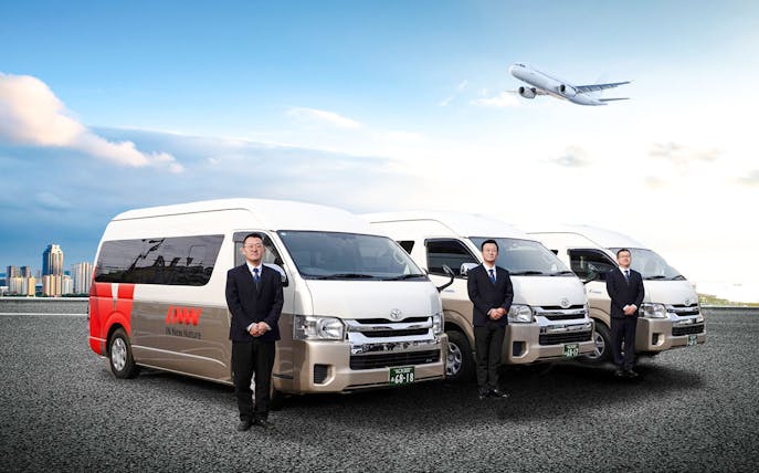Kansai Airport shared shuttle vans with attendants and airplane in the sky.