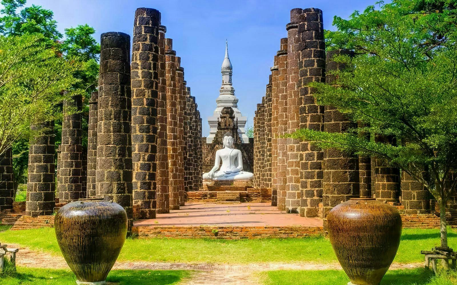 Buddha statue surrounded by ancient stone pillars at Muang Boran, Samut Prakan, Thailand.