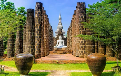 Buddha statue surrounded by ancient stone pillars at Muang Boran, Samut Prakan, Thailand.