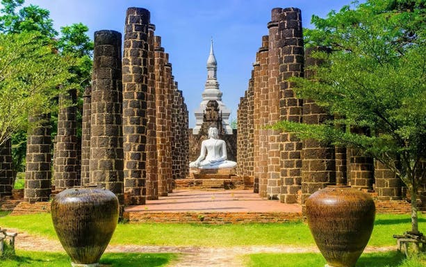 Buddha statue surrounded by ancient stone pillars at Muang Boran, Samut Prakan, Thailand.