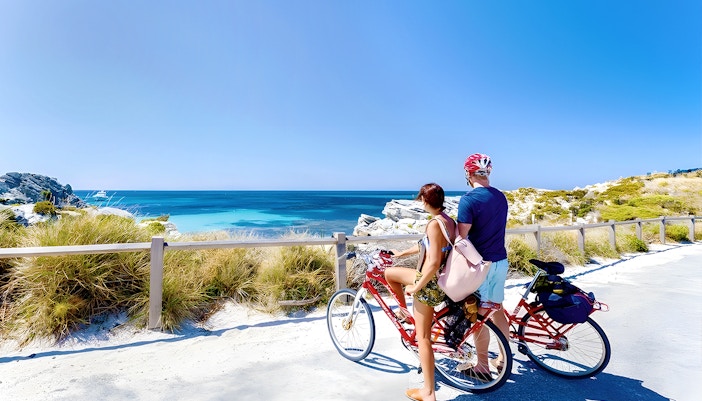 Tourists enjoying the Rottnest Island Ferry and Adventure Boat Tour, departing from Perth or Fremantle, with a view of the island's coastline