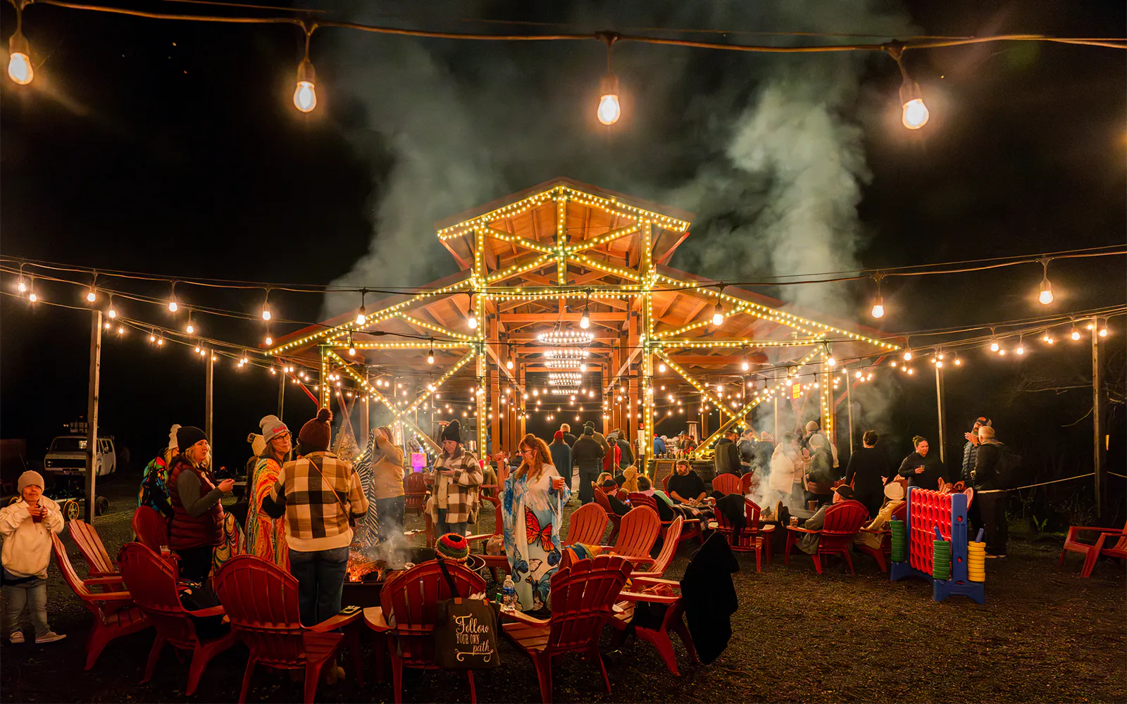 Outdoor gathering at Glen Blair Bar, San Francisco, with people around a fire pit under string lights.