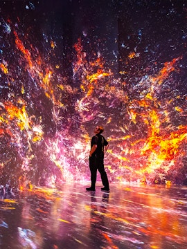 Person observing immersive digital art installation at ARTECHOUSE, New York.