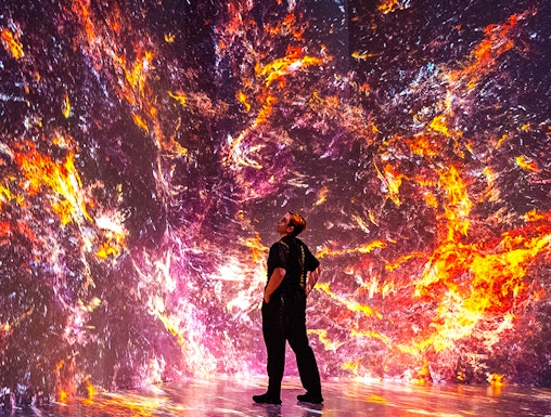 Person observing immersive digital art installation at ARTECHOUSE, New York.