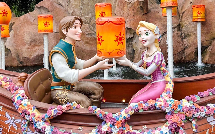 Characters in a boat holding lanterns during the Voyage to the Crystal Grotto.