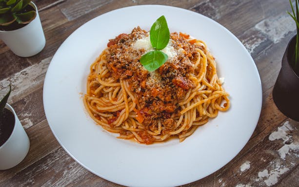 Spaghetti Bolognese with basil served on a white plate, part of the Florence Tuscan lunch experience.