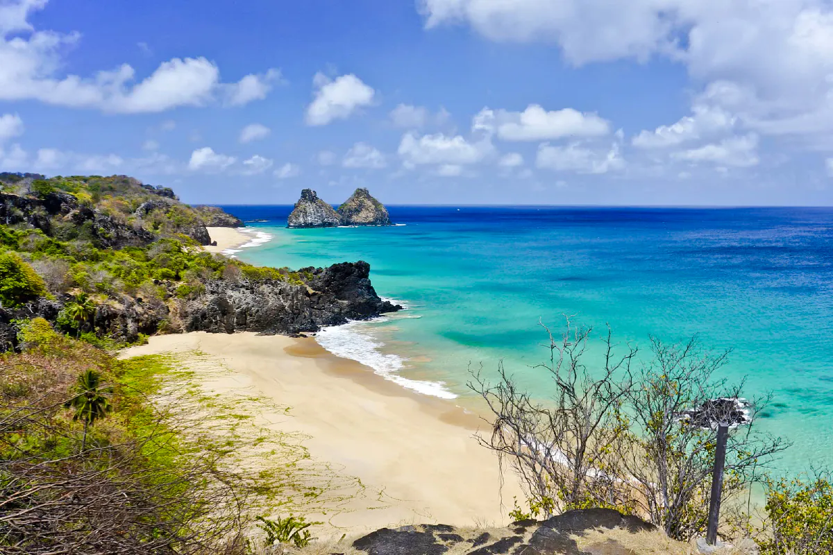 Sancho Beach view with turquoise waters and Dois Irmãos rocks, Noronha Island tour.