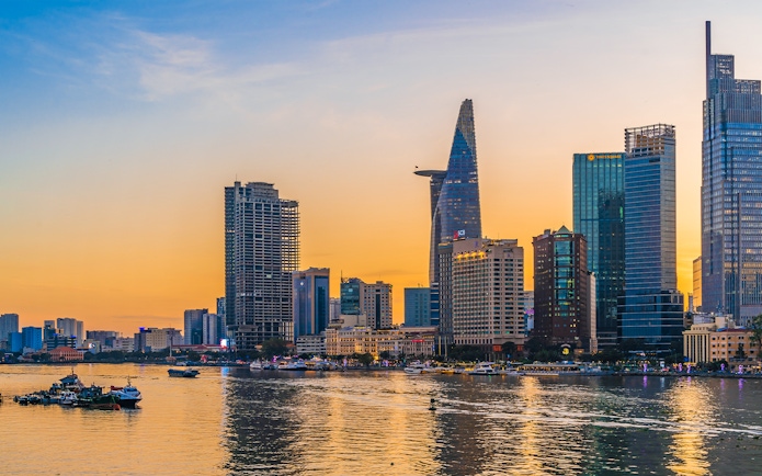 Cityscape of Ho Chi Minh City with Bitexco Financial Tower at sunset.