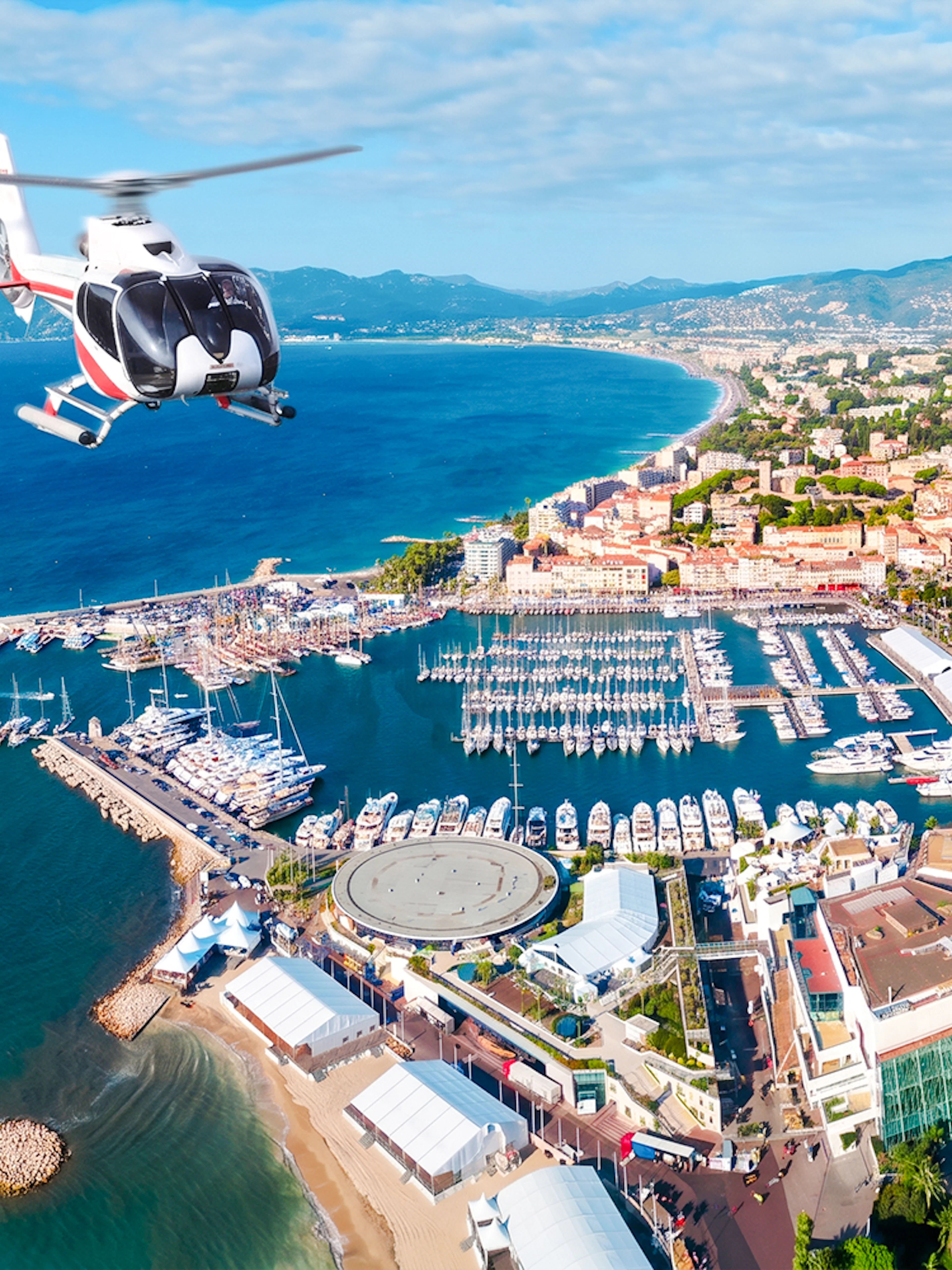 Helicopter flying over Cannes coastline and marina during panoramic tour.