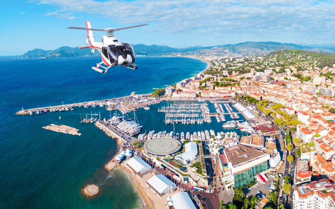Helicopter flying over Cannes coastline and marina during panoramic tour.