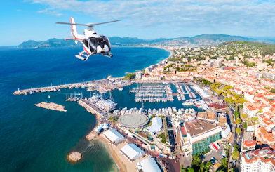 Helicopter flying over Cannes coastline and marina during panoramic tour.