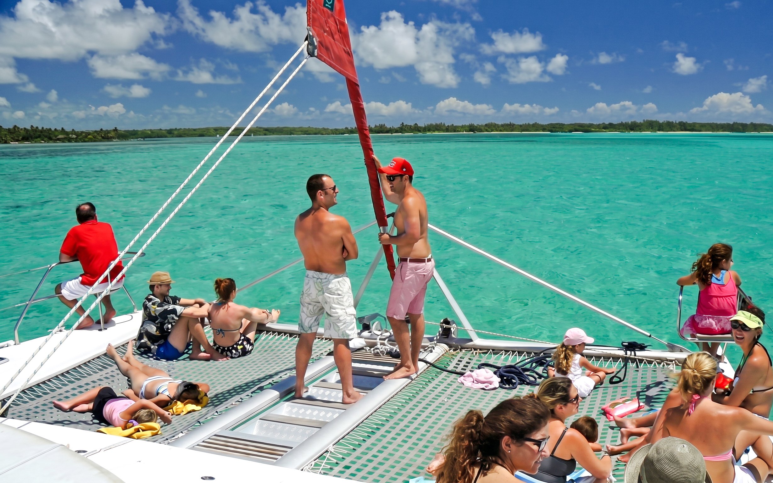 Catamaran with tourists sailing to Ile aux Cerf, Mauritius, enjoying the sun and sea.
