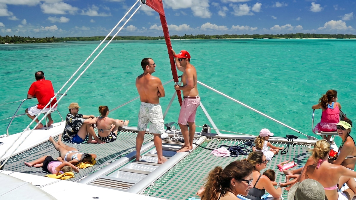 Catamaran with tourists sailing to Ile aux Cerf, Mauritius, enjoying the sun and sea.