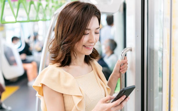 Person using smartphone on a train in Japan, illustrating WiFi rental service.